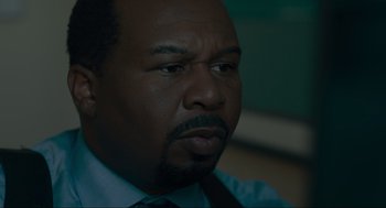 Movie still from “Confess, Fletch” (2022), directed by Greg Mottola – A person wearing a shirt and tie; Extreme Close Up shot, Over the shoulder angle