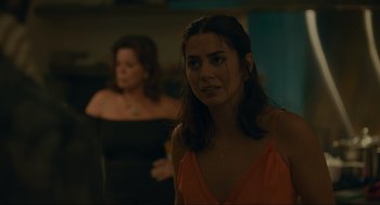 Movie still from “Confess, Fletch” (2022), directed by Greg Mottola – A woman standing next to another woman in a room; Close Up shot, Over the shoulder angle