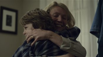 Movie still from “Contagion” (2011), directed by Steven Soderbergh – A woman hugging a boy in a room; Close Up shot, Over the shoulder angle