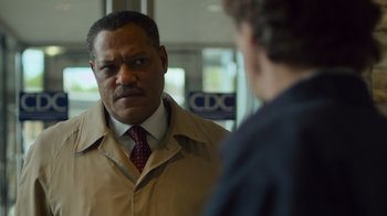 Movie still from “Contagion” (2011), directed by Steven Soderbergh – A man wearing a tan jacket and a red tie; Close Up shot, Over the shoulder angle