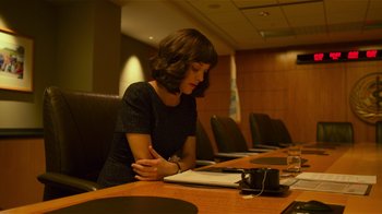 Movie still from “Contagion” (2011), directed by Steven Soderbergh – A woman sitting at a conference table with a laptop; Medium shot, Over the shoulder angle