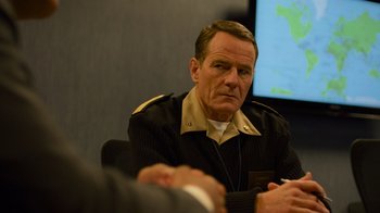 Movie still from “Contagion” (2011), directed by Steven Soderbergh – An older man in a military uniform sitting in front of a wall; Close Up shot, Over the shoulder angle