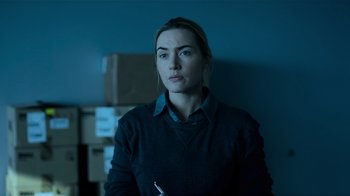 Movie still from “Contagion” (2011), directed by Steven Soderbergh – A woman is standing in a dark room; Medium shot, Over the shoulder angle