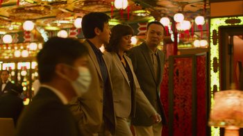 Movie still from “Contagion” (2011), directed by Steven Soderbergh – A group of people standing next to each other in a room; Medium shot, Over the shoulder angle