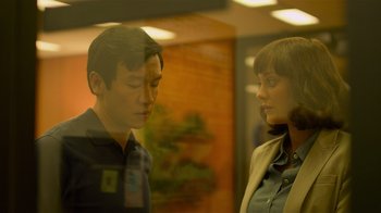 Movie still from “Contagion” (2011), directed by Steven Soderbergh – A man and a woman standing next to each other in a room; Close Up shot, Over the shoulder angle