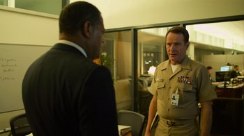 Movie still from “Contagion” (2011), directed by Steven Soderbergh – A man in a uniform talking to another man in a suit; Medium shot, Over the shoulder angle