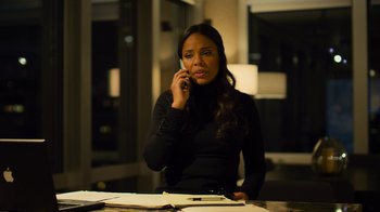 Movie still from “Contagion” (2011), directed by Steven Soderbergh – A woman sitting at a table talking on a cell phone; Medium shot, High angle