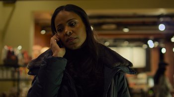 Movie still from “Contagion” (2011), directed by Steven Soderbergh – A woman is talking on a cell phone while wearing a black jacket; Close Up shot, High angle