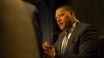 Movie still from “Contagion” (2011), directed by Steven Soderbergh – A man in a business suit clapping his hands; Close Up shot, Over the shoulder angle
