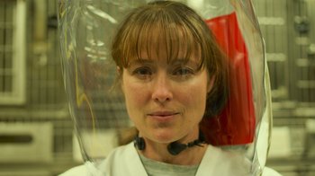 Movie still from “Contagion” (2011), directed by Steven Soderbergh – A woman wearing a white shirt is holding an umbrella over her head; Close Up shot, Over the shoulder angle
