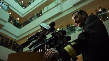 Movie still from “Contagion” (2011), directed by Steven Soderbergh – A man in a military uniform talking into microphones; Medium shot, Low angle