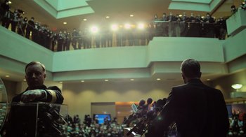 Movie still from “Contagion” (2011), directed by Steven Soderbergh – A crowd of people in a room with microphones; Wide shot, Low angle