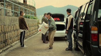 Movie still from “Contagion” (2011), directed by Steven Soderbergh – A group of people standing around a car; Wide shot, High angle