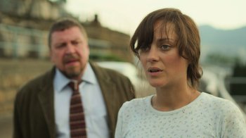 Movie still from “Contagion” (2011), directed by Steven Soderbergh – A man and a woman standing next to each other; Close Up shot, Over the shoulder angle