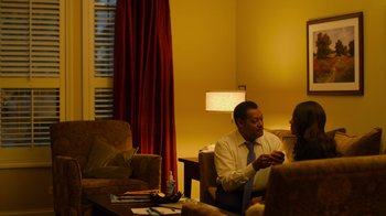 Movie still from “Contagion” (2011), directed by Steven Soderbergh – A man and a woman sitting in a living room; Medium shot, Over the shoulder angle