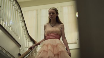 Movie still from “Contagion” (2011), directed by Steven Soderbergh – A woman in a pink dress standing on a staircase; Medium shot, Low angle