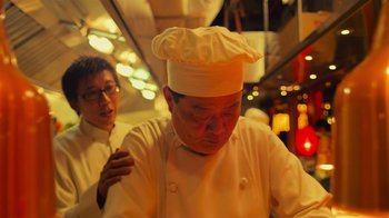 Movie still from “Contagion” (2011), directed by Steven Soderbergh – A man wearing a chef's hat in front of another man; Close Up shot, Low angle