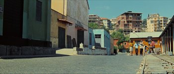 Movie still from “Contempt” (1963), directed by Jean-Luc Godard – A view of a street corner with buildings in the background; Extreme Wide shot, Low angle