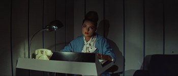 Movie still from “Contempt” (1963), directed by Jean-Luc Godard – A woman sitting in front of a computer monitor; Medium shot, Low angle