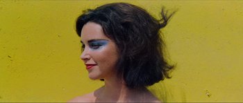 Movie still from “Contempt” (1963), directed by Jean-Luc Godard – A person wearing makeup on their face; Close Up shot, High angle