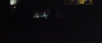 A person sitting in a dark room reading a book