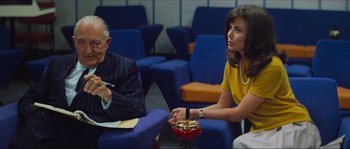 Movie still from “Contempt” (1963), directed by Jean-Luc Godard – Two people are sitting in chairs in a waiting room; Medium shot, Over the shoulder angle