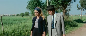 Movie still from “Contempt” (1963), directed by Jean-Luc Godard – A man and a woman standing next to each other in a field; Medium shot, High angle