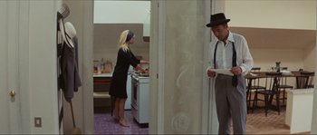 Movie still from “Contempt” (1963), directed by Jean-Luc Godard – A man and a woman standing in front of an oven; Medium shot, High angle
