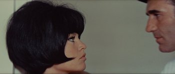 Movie still from “Contempt” (1963), directed by Jean-Luc Godard – A person with short black hair; Close Up shot, Over the shoulder angle