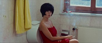 Movie still from “Contempt” (1963), directed by Jean-Luc Godard – A woman sitting on a toilet in a bathroom; Medium shot, High angle