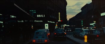 Movie still from “Contempt” (1963), directed by Jean-Luc Godard – Cars driving down a street at night in a city; Extreme Wide shot, Low angle