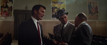 Movie still from “Contempt” (1963), directed by Jean-Luc Godard – A group of men standing next to each other in a room; Medium shot, Low angle