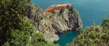 Movie still from “Contempt” (1963), directed by Jean-Luc Godard – A house sitting on top of a cliff near the ocean; Extreme Wide shot, High angle