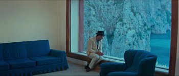 Movie still from “Contempt” (1963), directed by Jean-Luc Godard – A man sitting in front of a large window; Wide shot, Over the shoulder angle
