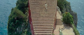 Movie still from “Contempt” (1963), directed by Jean-Luc Godard – A man is running up a set of stairs; Extreme Wide shot, High angle