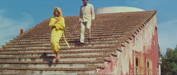 Movie still from “Contempt” (1963), directed by Jean-Luc Godard – A man and a woman walking up some stairs; Wide shot, Low angle