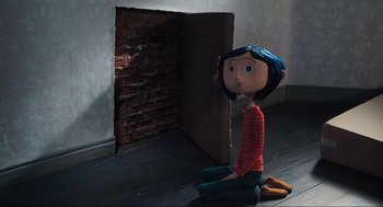 Movie still from “Coraline” (2009), directed by Henry Selick – A doll sitting on the floor in front of a door; Wide shot, High angle