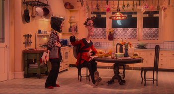 Movie still from “Coraline” (2009), directed by Henry Selick – A couple of people that are sitting in a room; Wide shot, High angle