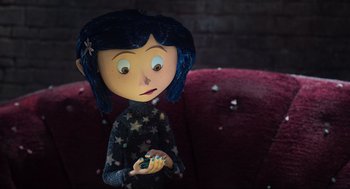 Movie still from “Coraline” (2009), directed by Henry Selick – A doll holding a piece of candy; Medium shot, Overhead angle