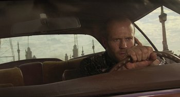 Movie still from “Crank” (2006), directed by Mark Neveldine – A man sitting in the driver's seat of a car; Close Up shot, Low angle