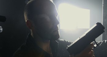 Movie still from “Crank” (2006), directed by Mark Neveldine – A man with a beard is holding a cell phone; Close Up shot, Low angle