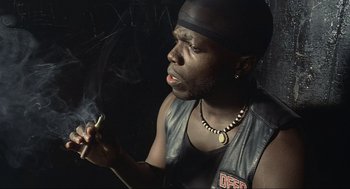 Movie still from “Crank” (2006), directed by Mark Neveldine – A man smoking a cigarette while wearing a leather vest; Close Up shot, Low angle