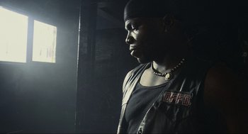 Movie still from “Crank” (2006), directed by Mark Neveldine – A man in a black shirt and a black hat; Close Up shot, Low angle