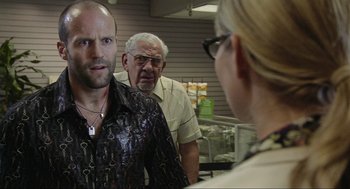 Movie still from “Crank” (2006), directed by Mark Neveldine – Two men and a woman in a store looking at each other; Close Up shot, Over the shoulder angle