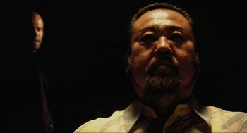 Movie still from “Crank” (2006), directed by Mark Neveldine – A person with a beard; Close Up shot, Low angle