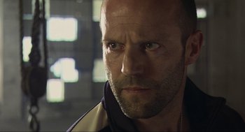 Movie still from “Crank” (2006), directed by Mark Neveldine – A man with a beard looking at the camera; Close Up shot, Low angle