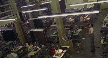 Movie still from “Crank” (2006), directed by Mark Neveldine – Many people are working in an industrial setting; Extreme Wide shot, High angle