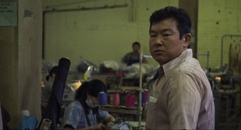 Movie still from “Crank” (2006), directed by Mark Neveldine – A man standing next to a woman in a room; Medium shot, Over the shoulder angle