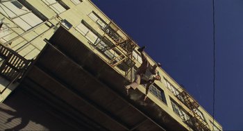 Movie still from “Crank” (2006), directed by Mark Neveldine – A man jumping off of a bridge into the air; Extreme Wide shot, Overhead angle