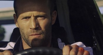 Movie still from “Crank” (2006), directed by Mark Neveldine – A person driving a car; Close Up shot, Low angle